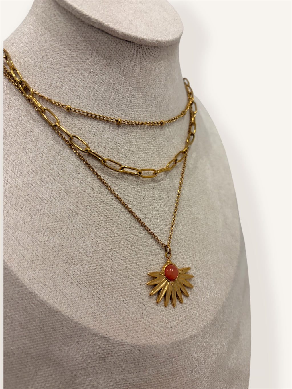 Composition de chaines dorées avec pendentif soleil corail